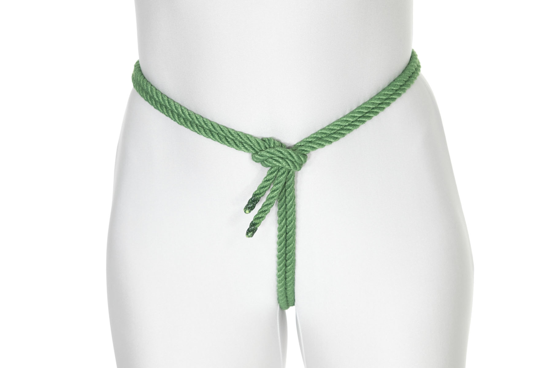 A green rope comes between a person’s legs and up their crotch to their waist. The rope turns to the right and goes all the way around the waist. When it gets back to the right hand turn, it crosses under itself and makes a half hitch knot.