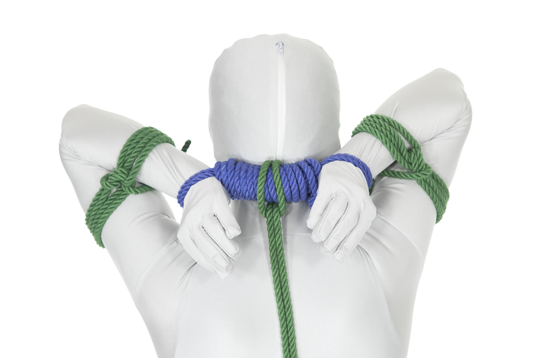 A closeup rear view of a person with their hands tied behind their back by a blue bar tie. A green rope has been attached to the bar tie with a larks head and goes down the body and out of frame. A frapped single column tie has been tied around each arm, binding the upper and lower arms together.