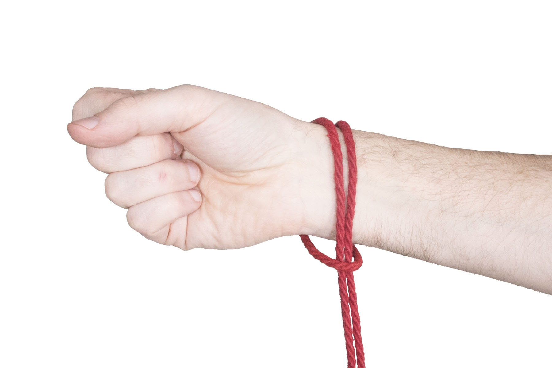 The rigger’s right hand has a lark’s head over the wrist. The lark’s head is tied in 4 milimeter red hemp rope. The bight of the rope comes up over the front side of the wrist and down the back side. Just below the wrist, the ends of the rope go through the bight and hang downward.