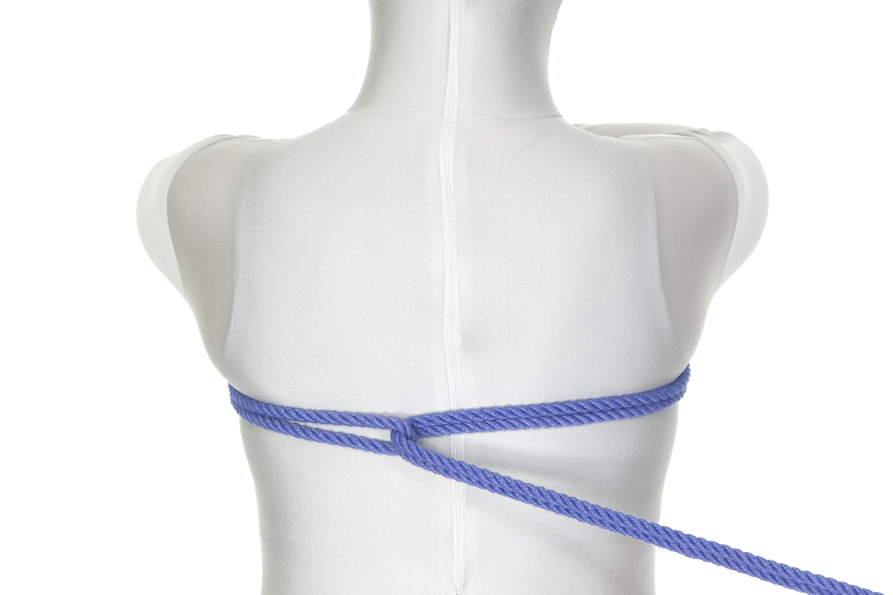 We are looking at the back of a person in a white bodysuit. The bight of a doubled blue rope has been wrapped all the way around the upper chest, going under the right armpit, across the front of the chest, and back under the left armpit. The bight ends up two inches to the left of the spine. The end of the rope makes a reverse tension through the bight and is pulled taut to the right of the frame.