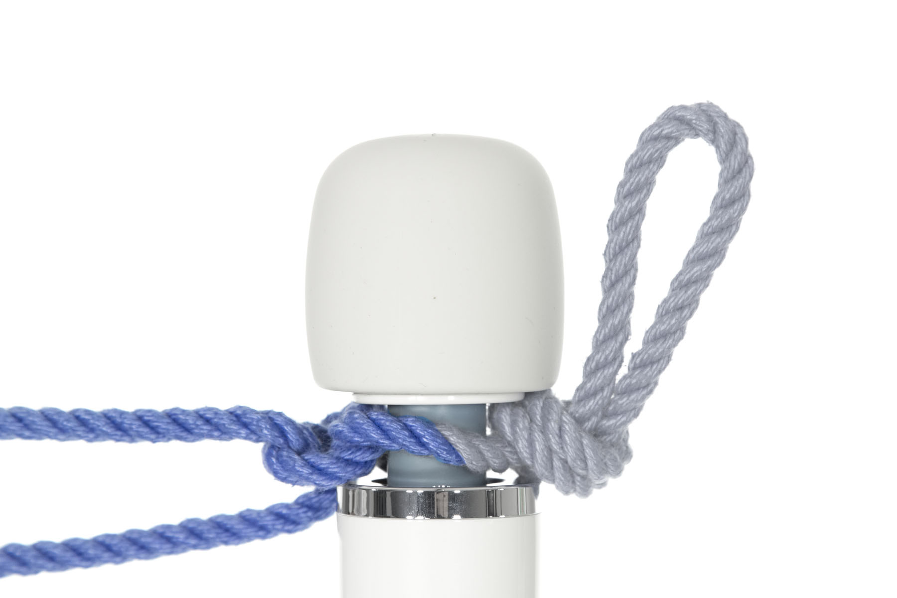 The base of the overhand knot is snug against the right side of the blue shaft of the vibrator. The ends of the rope are split, with one going around one side of the shaft and one going around the other side of the shaft. They meet on the left side of the shaft, where they are tied together with a square knot.