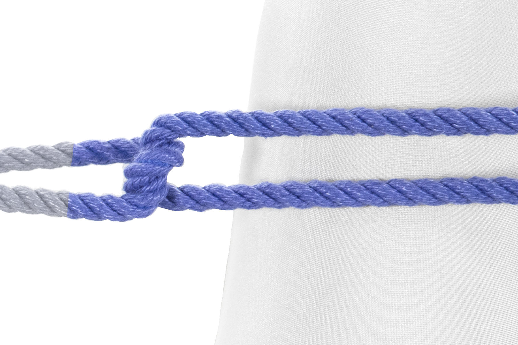 A closeup of the blue rope meeting the right leg. Just before it reaches the leg, the two parts of the rope separate slightly and are tied together with an overhand knot. They then continue to the right, lying on top of the right leg. The overhand knot makes a vertical twist that separates the two halves of the rope, about one inch to the left of the right leg.