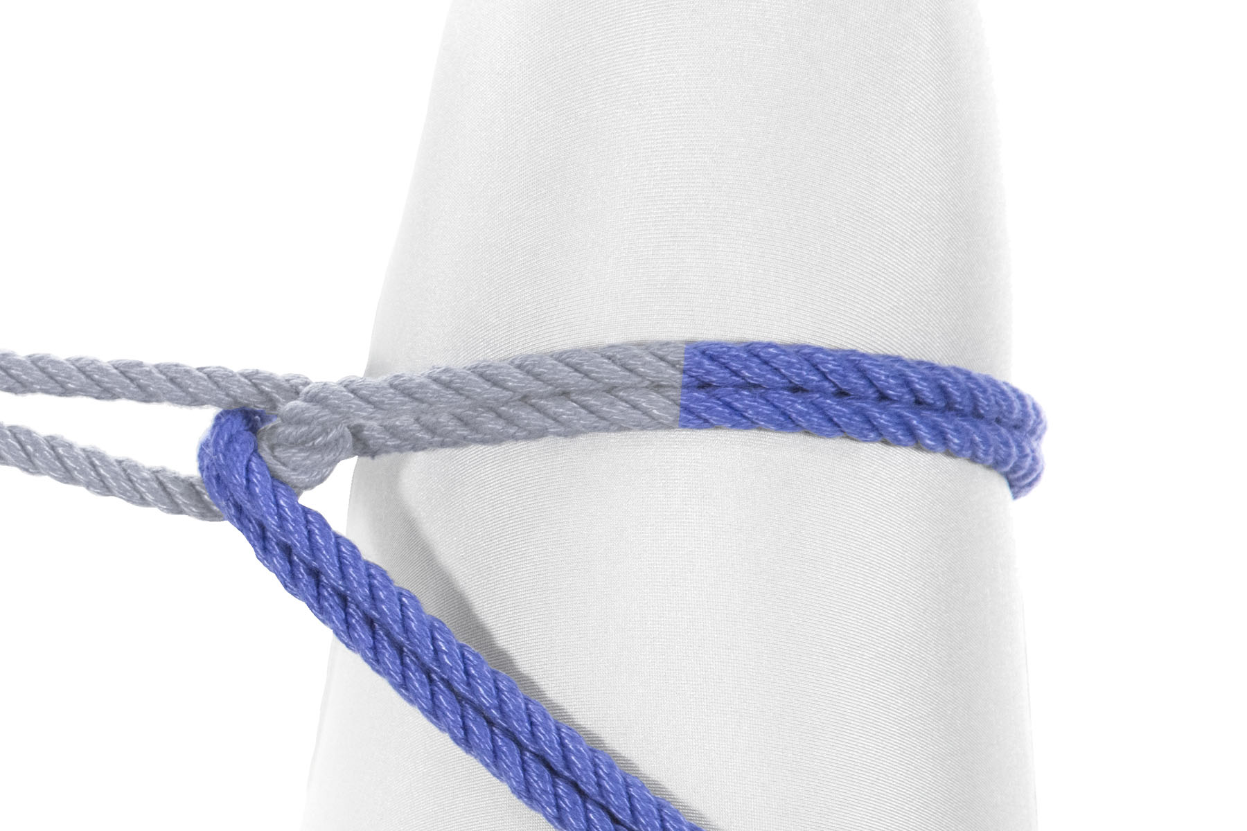 The rope makes a single clockwise wrap around the leg, six inches above the knee. At the end of the wrap, it passes over the overhand knot from the previous step, passing in between the two halves of the standing part of the rope. It then travels down and right, exiting the image.