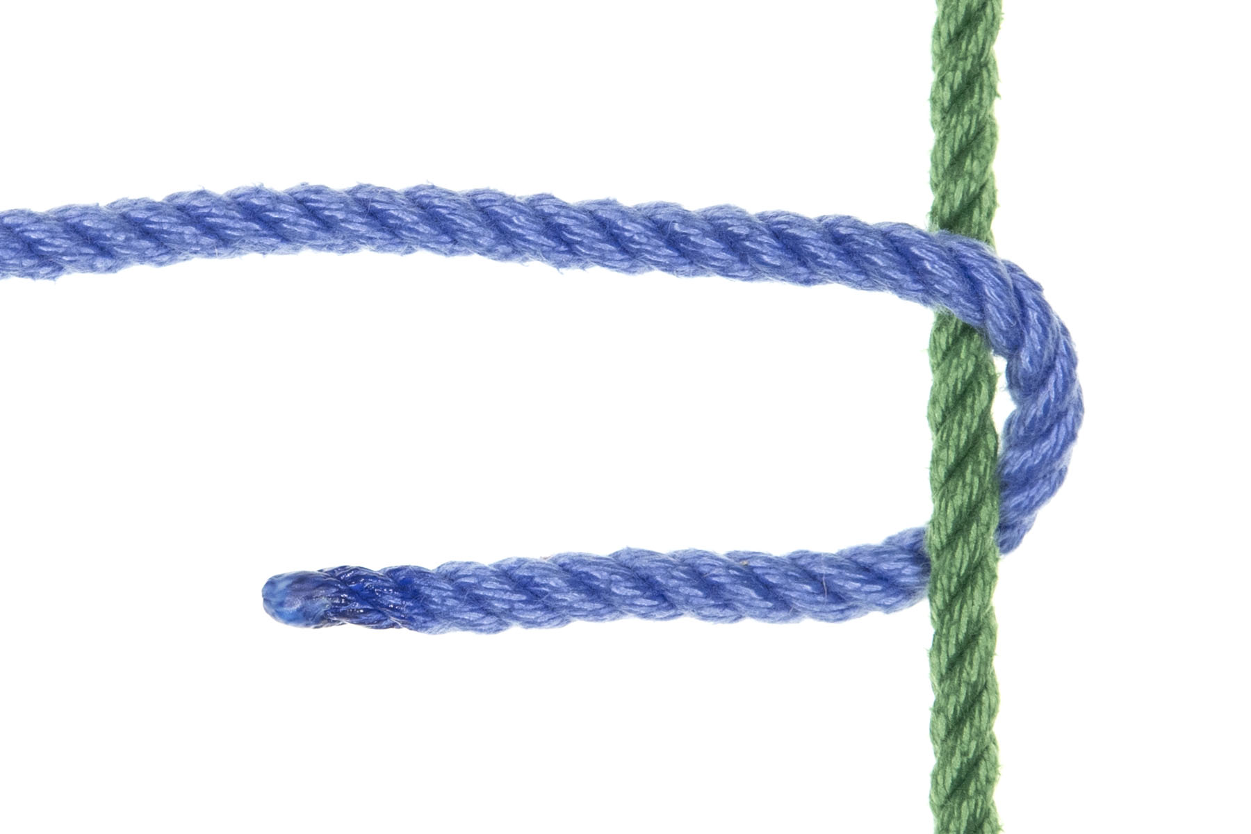 A single green rope passes vertically through the frame. A blue rope enters from the left of the frame and crosses over the green rope. It then doubles back, crossing under the green rope below where it crossed over it.