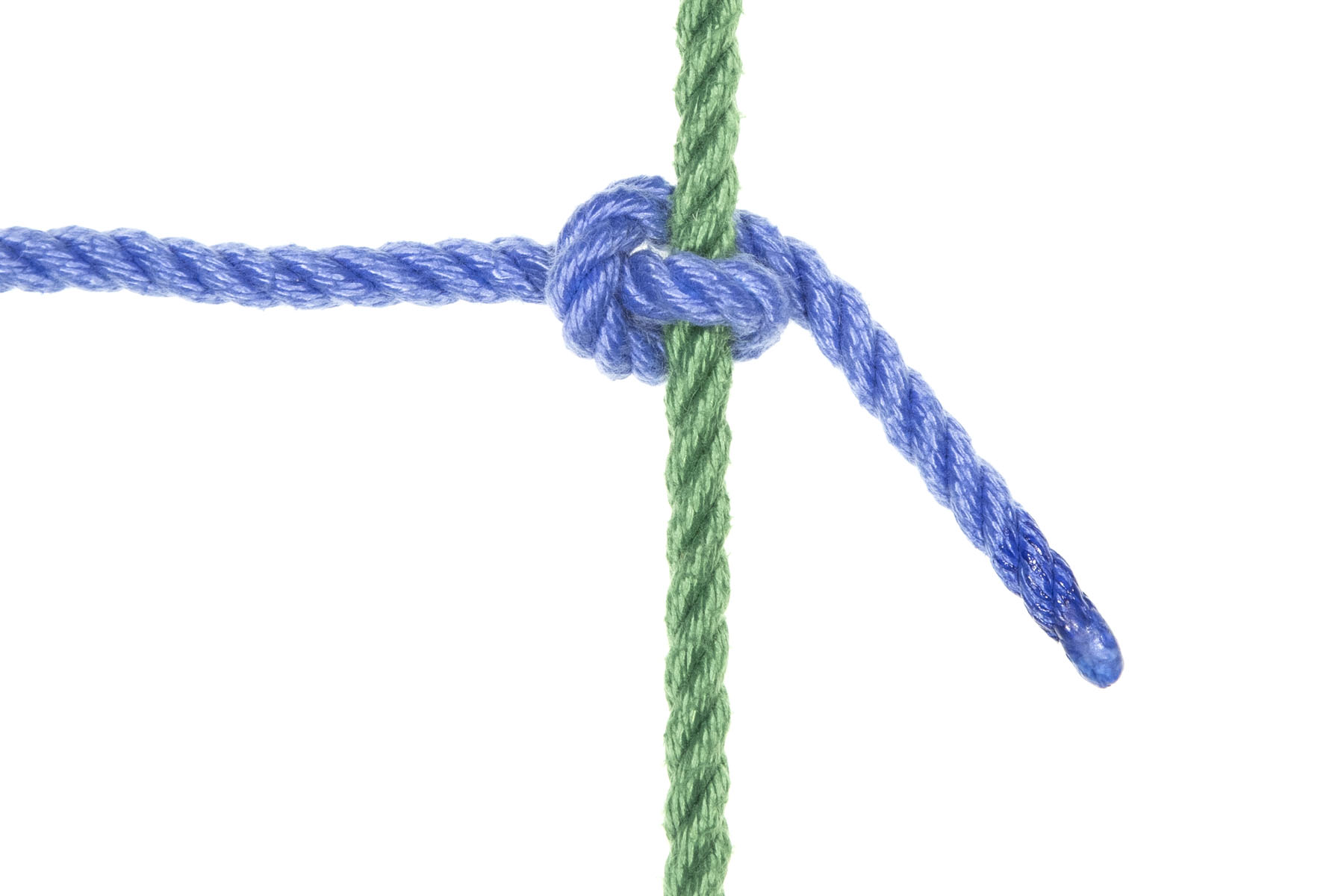 A green rope crosses the frame vertically. A blue rope enters from the left and makes a Munter at the green rope before exiting downward at 45 degrees. This blue rope crosses over the green rope, comes back under the green rope but lower in the frame, then crosses over itself moving upward before going under the green rope again. The 45 degree exit means that the blue rope is pulled into the Munter, tightening it.
