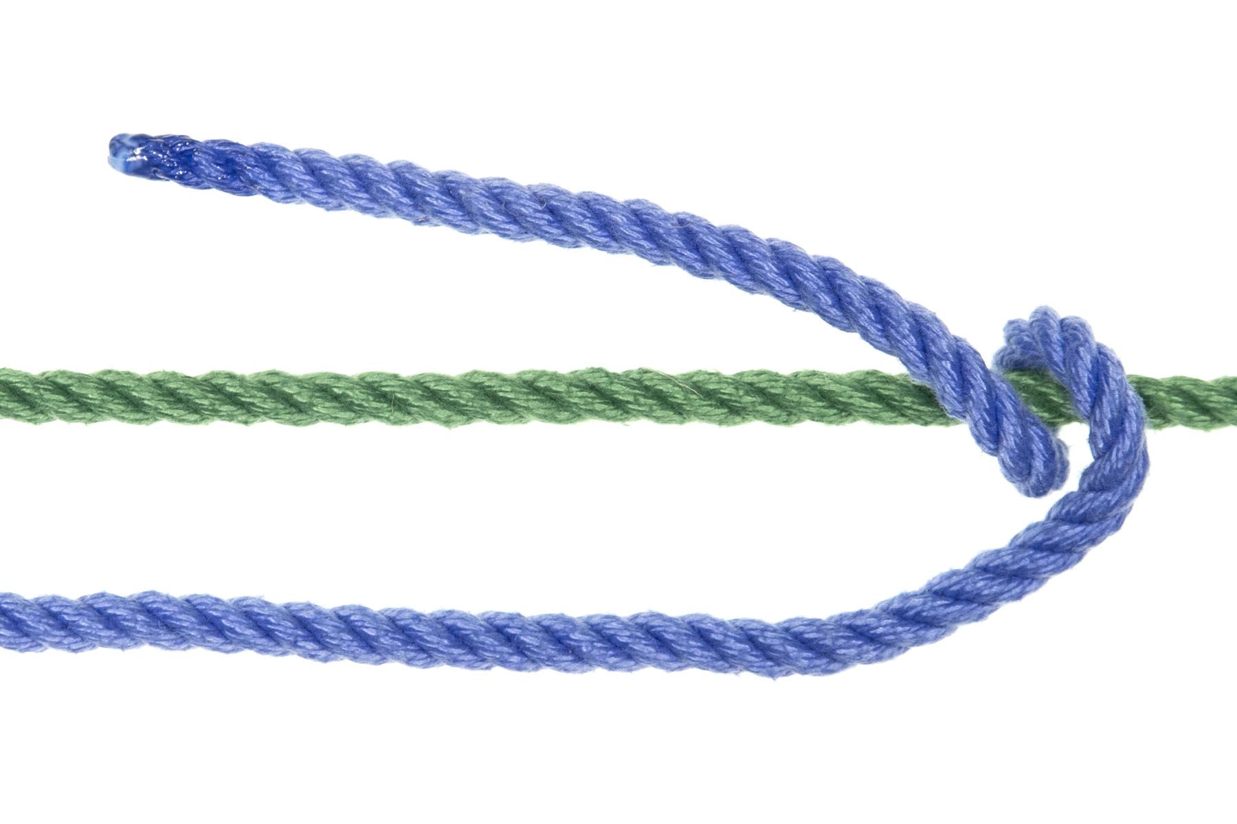 A green rope crosses the frame horizontally. A blue rope enters from the left and runs parallel to the green rope, one inch below it. Near the right edge of the frame, the blue rope crosses over the green rope and makes a full spiral around it, moving back toward the left. The blue rope goes over the green rope, under the green rope, and back over the green rope, with six inches of rope remaining and travelling back toward the left of the frame, one inch above the green rope.