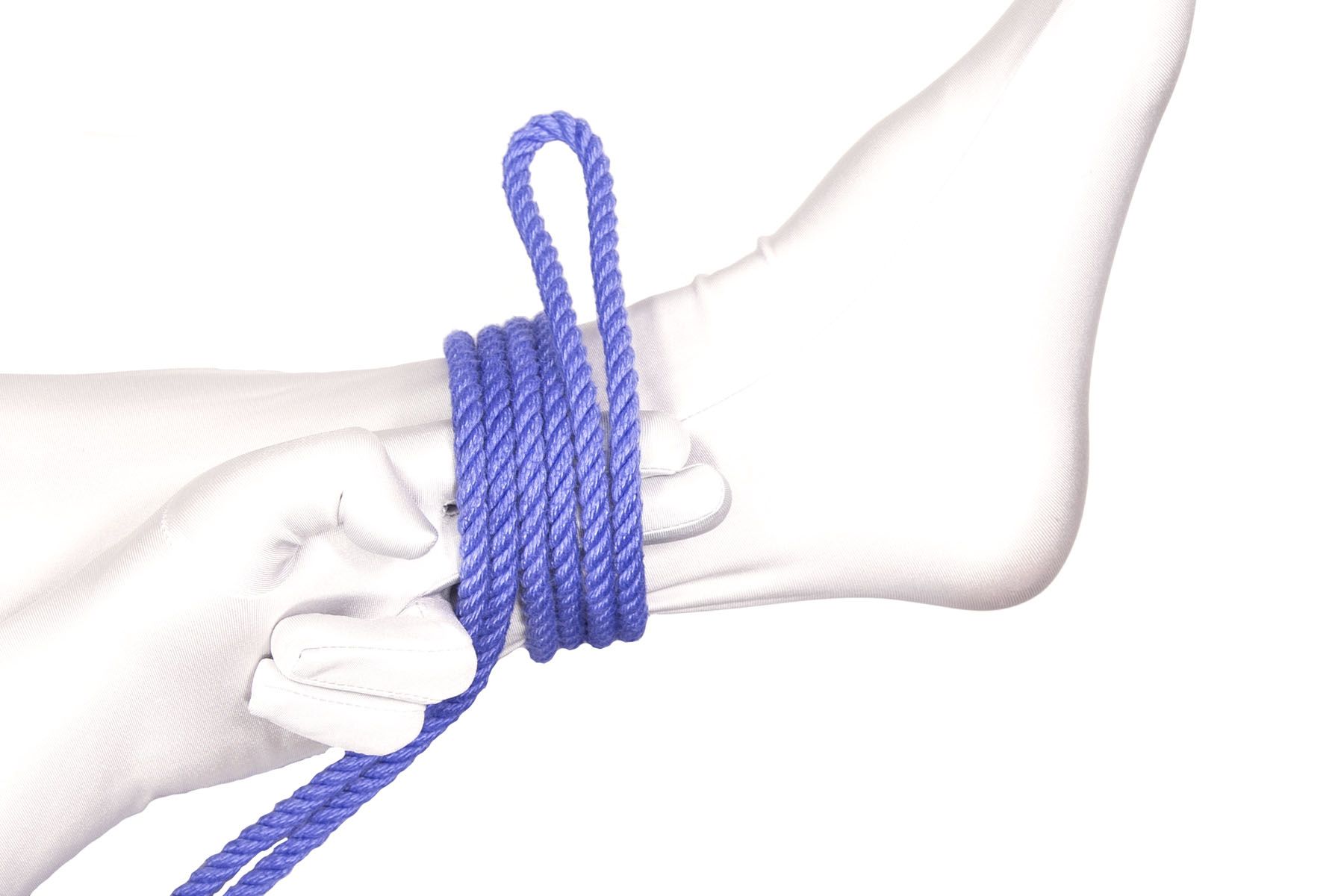 A doubled blue rope has been wrapped around the ankle twice. The rope goes over the index and middle fingers, over the top of the ankle, behind the ankle, and back under the bottom of the ankle. The second wrap is closer to the foot than the first wrap. A six inch bight hangs off the top of the ankle.