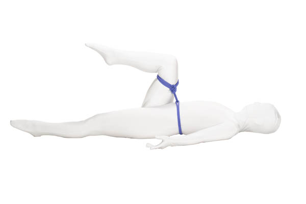 A person in a white bodysuit is lying on their back, with their right leg raised. The right knee is bent so the lower leg is parallel to the ground. A blue rope attaches to their waist with a lark’s head and then connects to the right leg just above the knee, where it is secured with a hojo cuff.