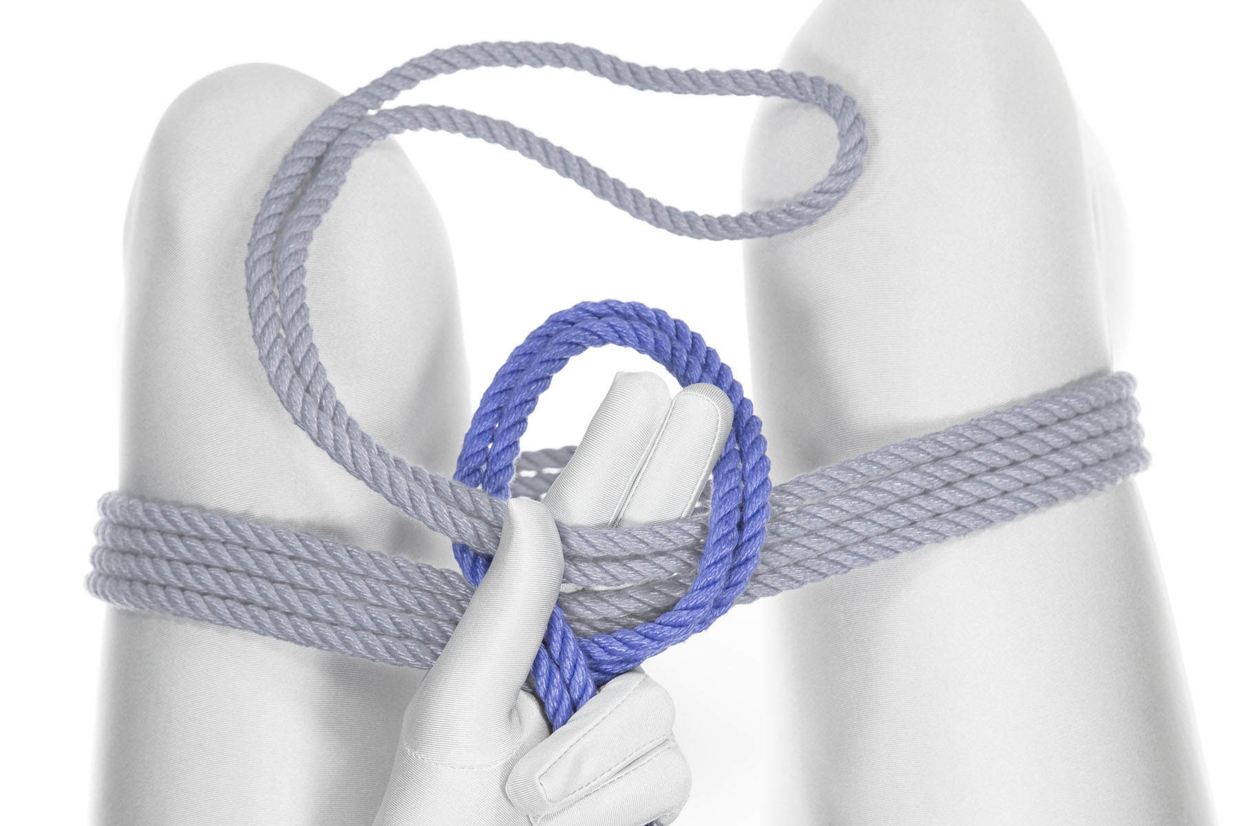 The standing part of the rope has made a four inch diameter loop around the bight. The bight and the index and middle fingers both pass upward through the loop. The standing part makes an X shape where it crosses over itself right by the base of the thumb.