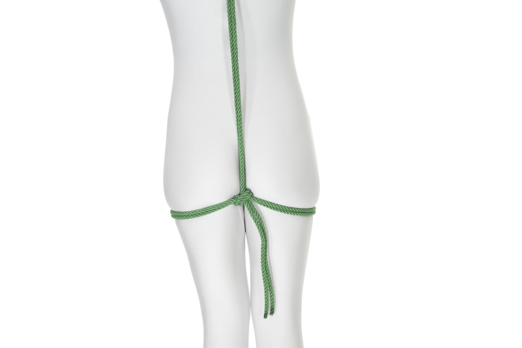 A rear view of a person. A green rope enters the frame in the upper back and goes down their body. Below the buttocks it turns right and goes all the way around the body, making a tight wrap that is held in place by the buttocks. When it gets back to the starting point, it makes a half hitch around itself.