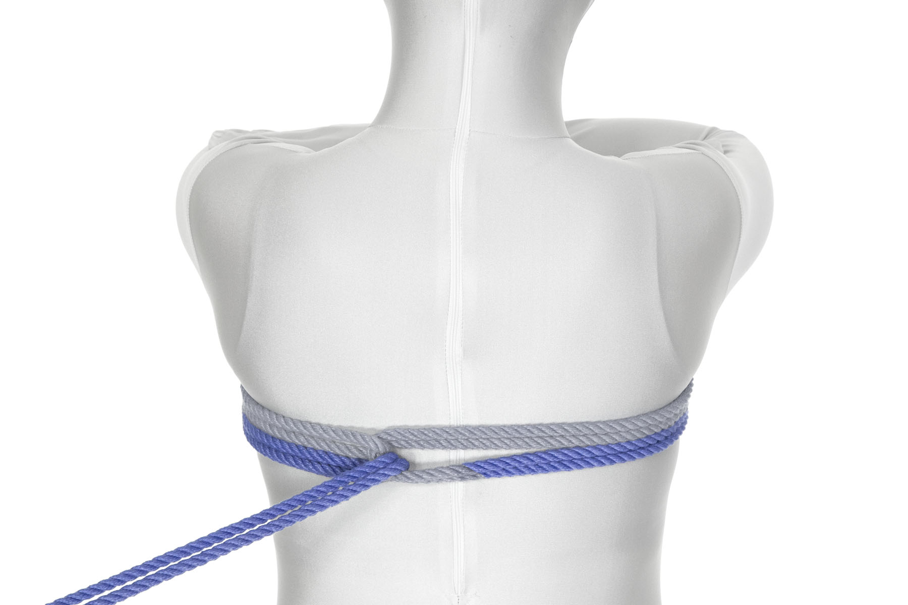 The rope makes a second wrap all the way around the chest, just under the first wrap. It makes a reverse tension through the U shape created by the first reverse tension and is pulled taut off to the left of the frame.