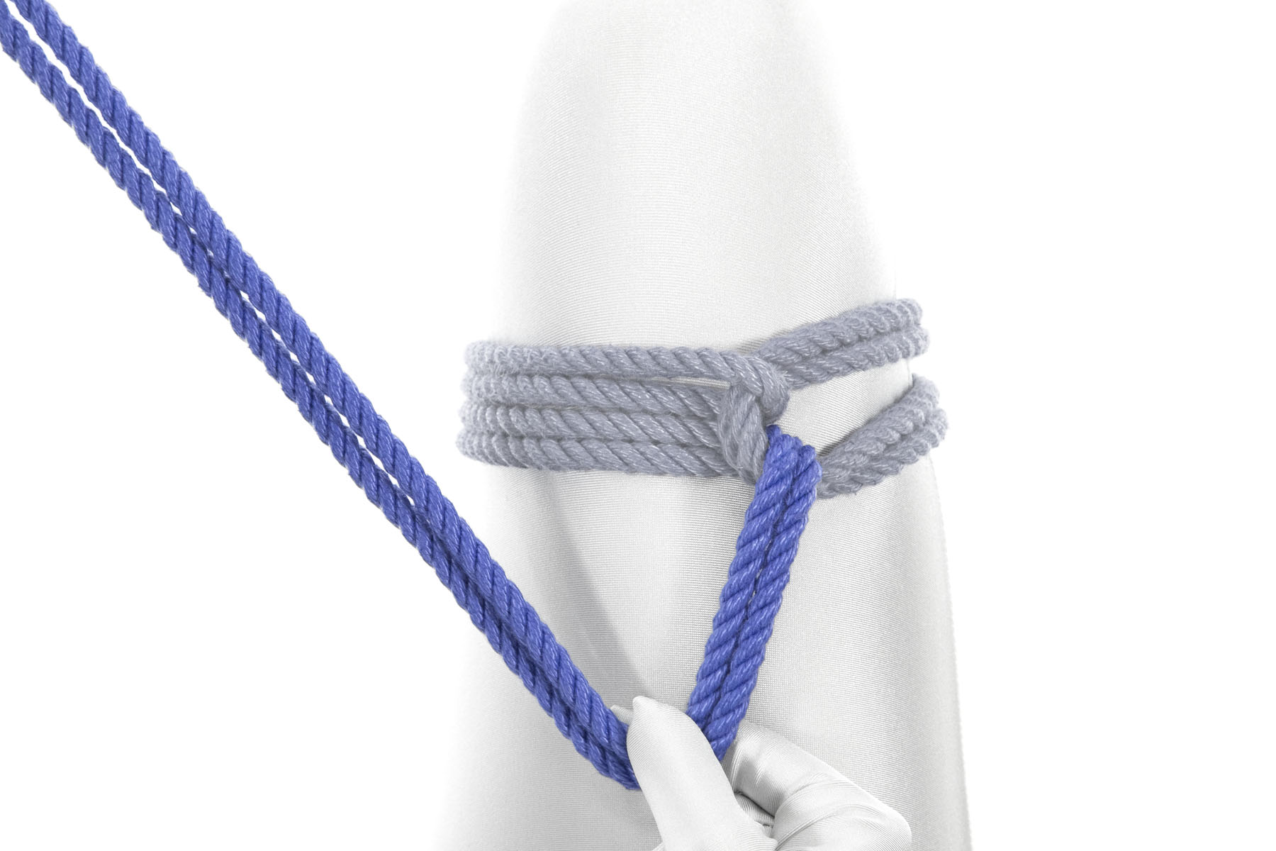 The rigger has pulled the working end to the left and up their thigh. Four inches along its length, they have pinched the rope between their thumb and forefinger. Their left hand is pulling the remainder of the working end to the left and down the thigh, so the rope makes a triangle pointing toward the body.