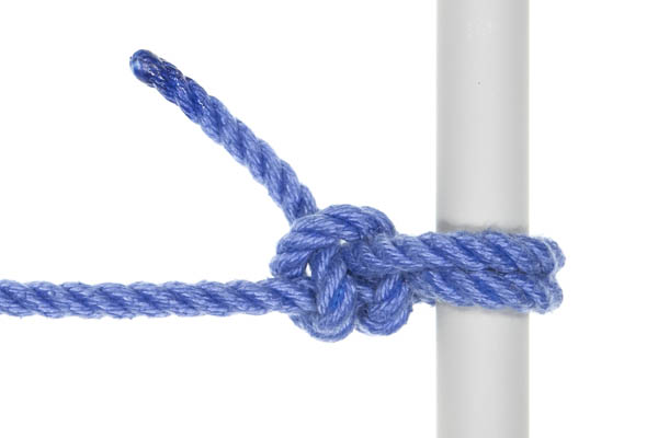 A round turn and two half hitches tied around a gray pole.