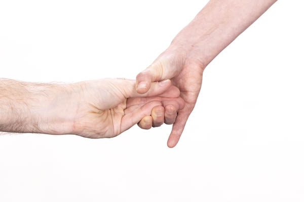 The bottom’s hand enters from the left, with the fingers and thumbs touching at the fingertips. The rigger’s hand enters from the upper right and is squeezing the bottom’s fingers and thumb together.
