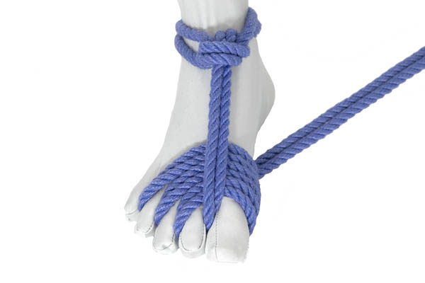 A foot in a white bodysuit with blue rope tied around the ankle and threaded between the toes.