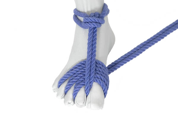 A foot in a white bodysuit with blue rope tied around the ankle and threaded between the toes.